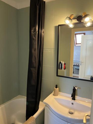 une salle de bain avec un lavabo, une baignoire et un miroir dans l'établissement Villa Médaillon, Appartement privé dans villa, vue mer, à Criel-sur-Mer