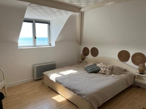 une chambre avec un grand lit et une fenêtre dans l'établissement Villa Médaillon, Appartement privé dans villa, vue mer, à Criel-sur-Mer