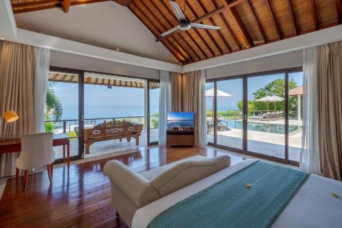 a bedroom with a bed and a view of the ocean at Karang Saujana in Uluwatu