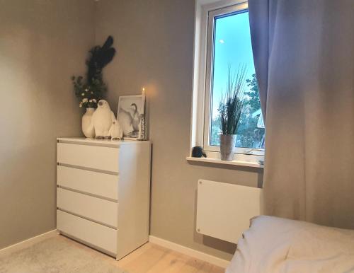a bedroom with a white dresser and a window at Modernt fritidshus med havsutsikt Mönsteråsviken in Mönsterås