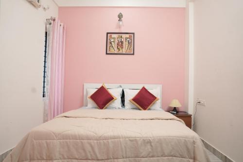 a bedroom with a large bed with pink walls at AVANTI CASTELLO in Guruvāyūr