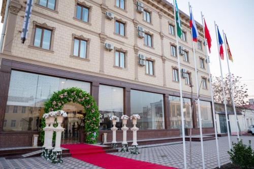 a building with a red carpet in front of it at Reikartz Fergana in Fergana