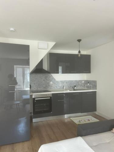 une cuisine avec des armoires grises et un évier dans l'établissement Oasis Getaway, à Peillac