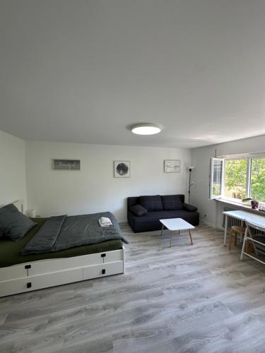 a bedroom with a bed and a couch and a table at Renovated Flat - Prime Location Near Marienplatz in Stuttgart
