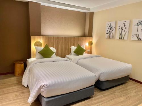 a hotel room with two beds in a room at Mybed Gold Chonburi in Ban Lang Khao