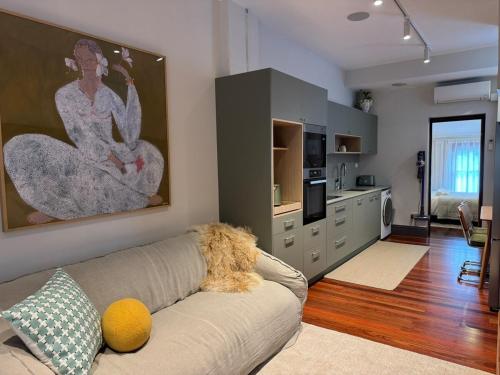 a living room with a couch and a kitchen at Chez Mimi, Elegant City Escape in Sydney