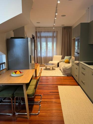 a kitchen and living room with a table and a couch at Chez Mimi, Elegant City Escape in Sydney