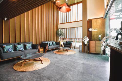 a lobby with couches and tables in a building at Mybed Gold Chonburi in Ban Lang Khao