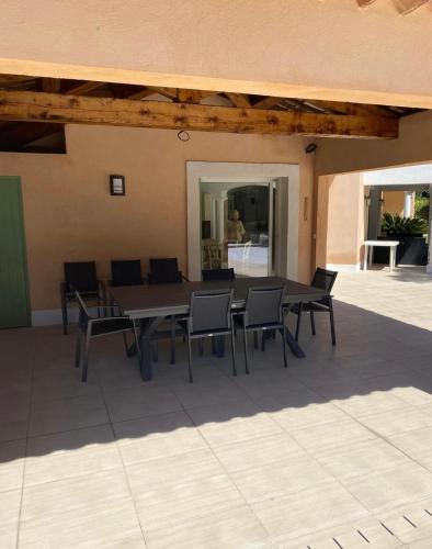 a table and chairs sitting on a patio at Belle villa dans clos privé - Saint Raphaël Boulouris in Saint-Raphaël