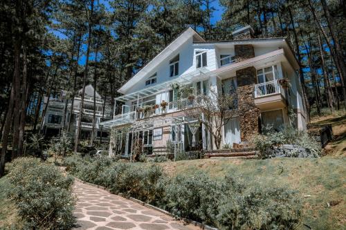 a white house on a hill with trees at Dahlia Dalat in Xuan An