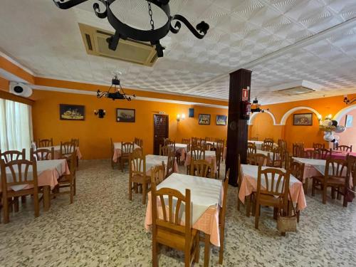 a restaurant with tables and chairs and a chandelier at El Faisan C&R Hotel in Arcos de la Frontera