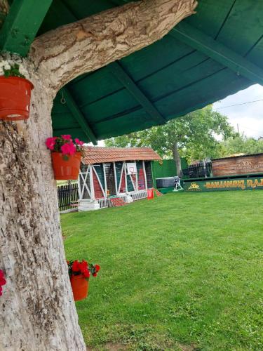 a tree with flower pots and a pavilion in a park at BANJANSKI RAJ in Arandjelovac