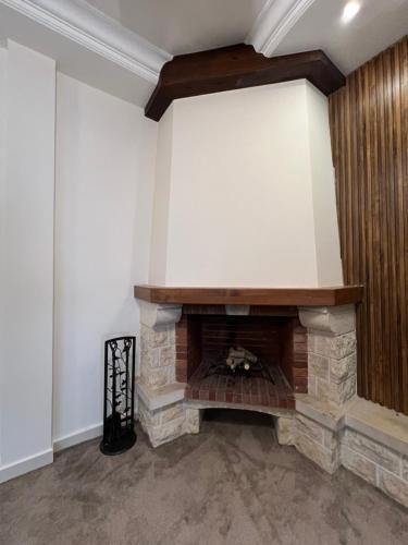 a living room with a stone fireplace in a wall at Modern Luxe Getaway in Amman