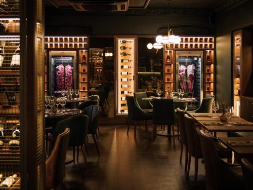 a restaurant with tables and chairs and wine racks at The Priory Hotel in Newport