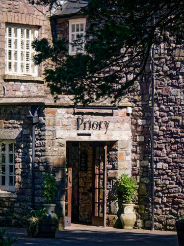 an entrance to a stone building with a sign that reads priory at The Priory Hotel in Newport