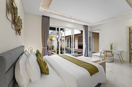 a bedroom with a large white bed and a balcony at Serava Villa by Kozystay - Canggu in Canggu