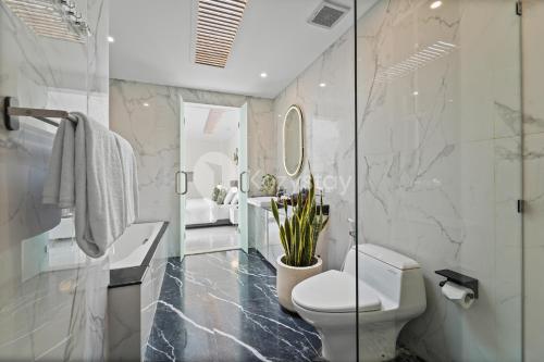 a bathroom with a toilet and a sink and a mirror at Serava Villa by Kozystay - Canggu in Canggu