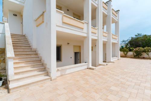 a row of white buildings with stairs on a patio at Residence Punta Pizzo in Marina di Mancaversa
