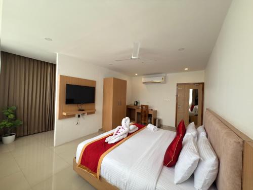 a bedroom with a bed with two stuffed animals on it at Mountain Pass Residency in Edakkara