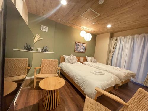 a room with two beds and a table and chairs at OPEN SALE! Stylish Stay near AKIHABARA! May2025 Open! 秋葉原 CORE HOTEL in Tokyo