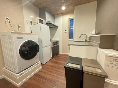 a kitchen with a washing machine and a sink at OPEN SALE! Stylish Stay near AKIHABARA! May2025 Open! 秋葉原 CORE HOTEL in Tokyo