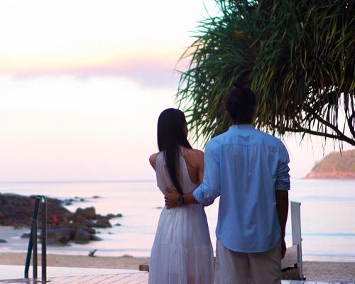 a couple standing on the beach looking at the ocean at The Boathouse Phuket-SHA Plus in Kata Beach