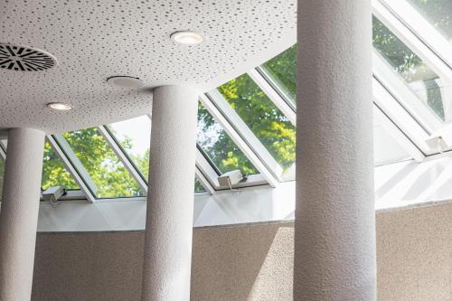 a room with columns and windows in a building at Hotel Raphael im Allgäu in Kempten