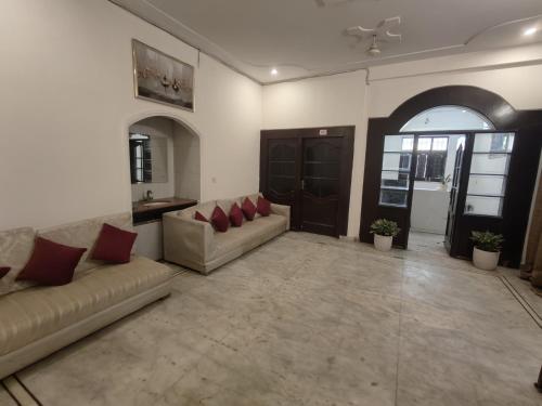 a living room with two couches and a table at Maira Retreat in Faridabad