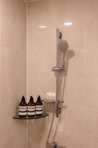 a shower with three jars on a shelf in a bathroom at Wecostay Cheongnyangni in Seoul