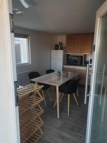 une cuisine avec une table et des chaises dans une pièce dans l'établissement Au pied de la Forêt !, à Oyonnax