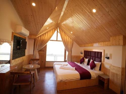 ein Schlafzimmer mit einem großen Bett in einem Holzzimmer in der Unterkunft Wooden Castle Hotel and Resort in Manali