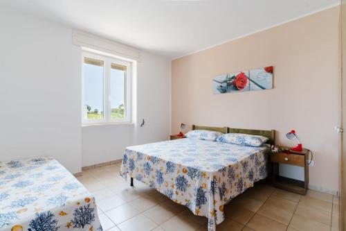 a bedroom with two beds and a window at Residence Punta Pizzo in Marina di Mancaversa