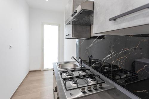 a kitchen with a stove and a sink at ApartHotel Angelo - Salento Reservation in Racale