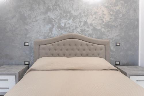 a bedroom with a bed with a gray wall at ApartHotel Angelo - Salento Reservation in Racale