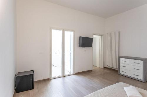 a bedroom with white walls and a bed and a dresser at ApartHotel Angelo - Salento Reservation in Racale