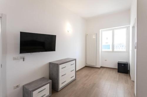 a white room with a tv and a dresser in it at ApartHotel Angelo - Salento Reservation in Racale