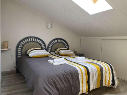 une chambre avec un grand lit avec des couvertures et des oreillers rayés dans l'établissement Langoustine Saint Hilaire de Riez, à Saint-Hilaire-de-Riez