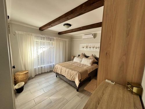 a bedroom with a bed and a window at Shamba Self-Catering in Pretoria