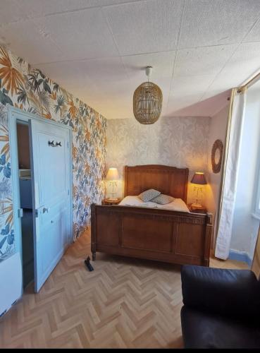 a bedroom with a bed and two lamps and a door at Le bonheur est dans le pré in Feusines