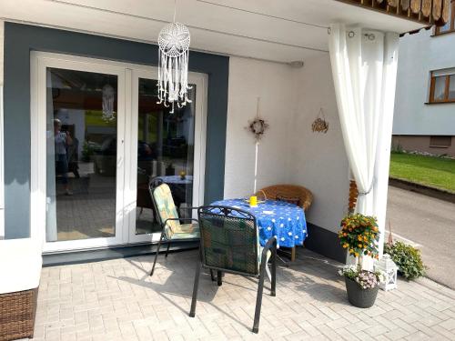 a table and chairs on a porch with a chandelier at Morgensonne in Gutach im Breisgau