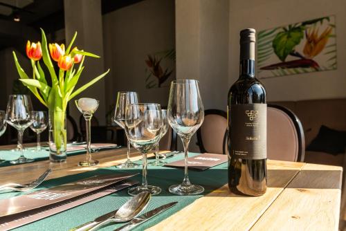 a bottle of wine sitting on a table with wine glasses at Hotel Nafta Krosno in Krosno