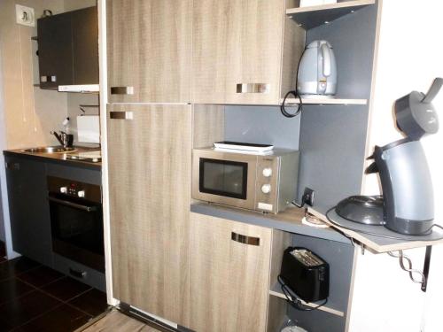 une petite cuisine avec un four micro-ondes sur une étagère dans l'établissement Résidence Oncet - Studio cosy et cocooning refait a neuf au cœur de Barèges MAE-0863, à Barèges