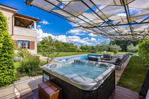 a hot tub in a backyard with a pergola at Villa Roza by Briskva in Bašići