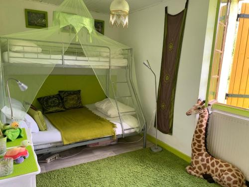 - une chambre pour enfants avec des lits superposés et un jouet de girafe dans l'établissement Jolie longère en pleine nature, à Prayssac