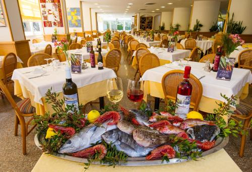 a plate of fish on a table in a restaurant at Ecoresort Le Sirene - Caroli Hotels in Gallipoli