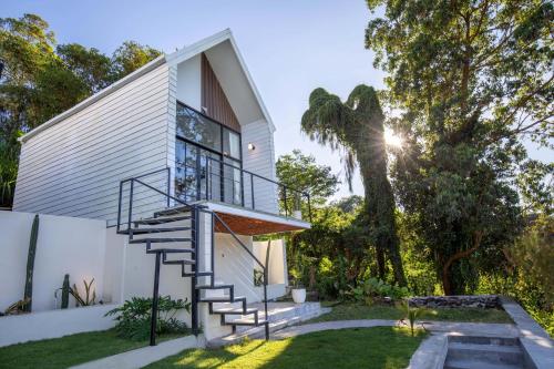 a house with a spiral staircase next to a yard at Faro Cabin Kintamani in Kintamani