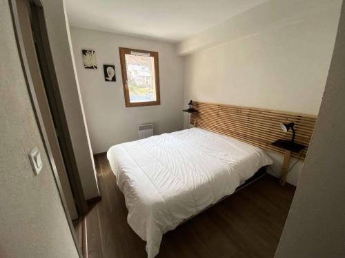 une petite chambre avec un lit blanc et une fenêtre dans l'établissement Résidence Bois De Marie - Appartement 8 couchages exposé SUD avec WIFI MAE-0913, à Barèges