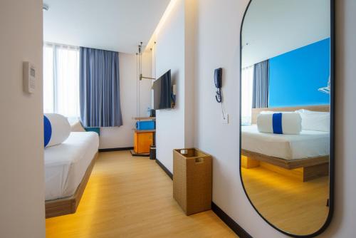 a mirror in a hotel room with two beds at COSI Vientiane Nam Phu in Vientiane