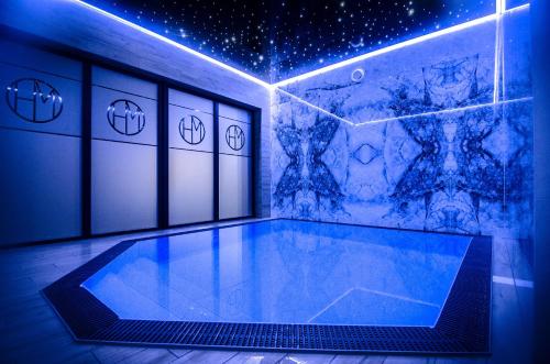 a room with a swimming pool with blue lights at Mielno Hotel Boutique in Mielno