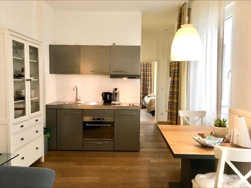 a kitchen with stainless steel appliances and a wooden table at Stein Boardinghouse in Koblenz